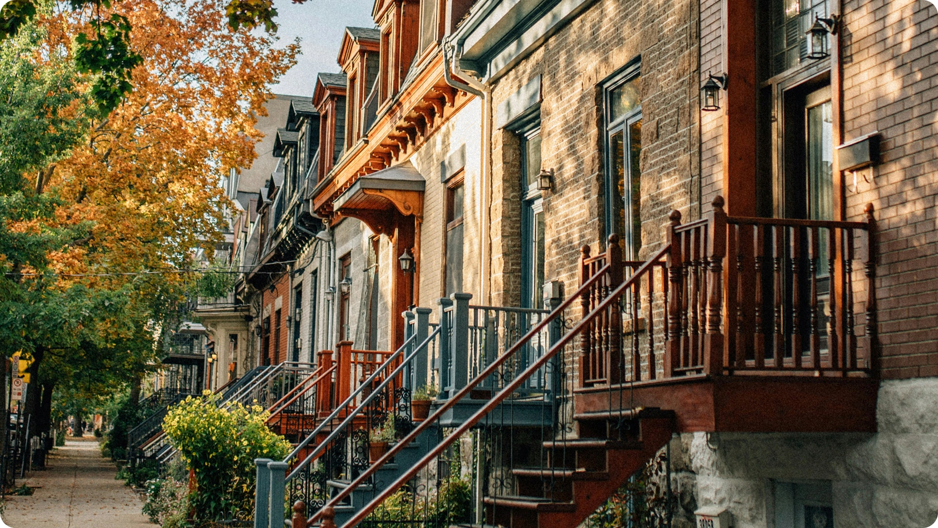 Townhomes on a residential street surrounded by mature trees.