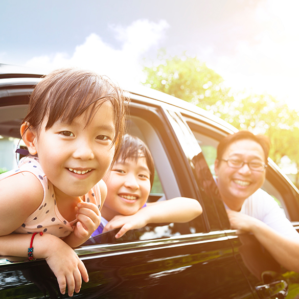 Happy family looking out car windows.