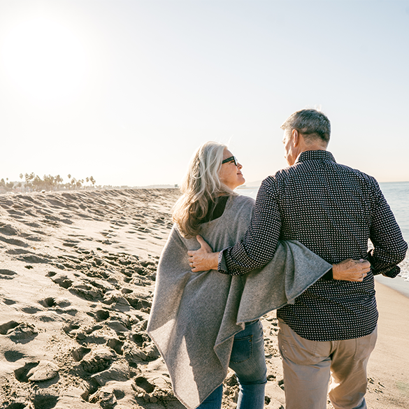 Mature couple walking on the beach.