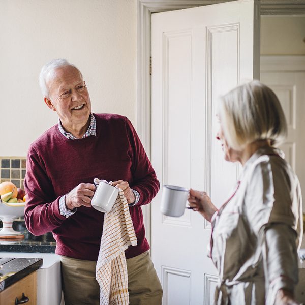 Older couple drying dishes in the kitchen.