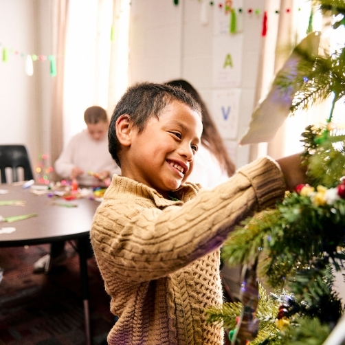Young boy decorating Christmas tree